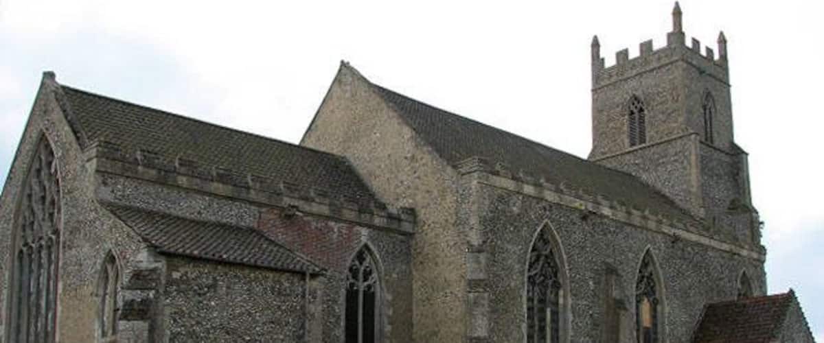 A historic stone church with a tall tower and arched windows.