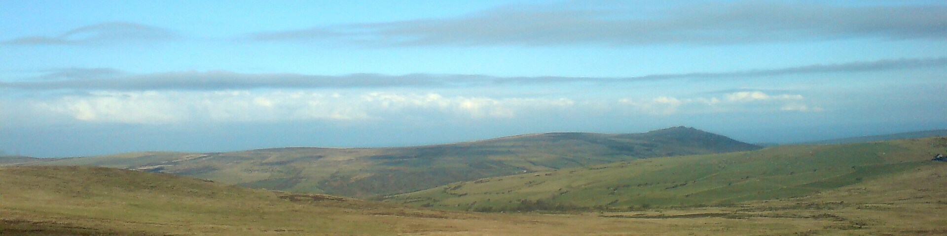 A vast, open landscape with rolling hills and a clear sky.