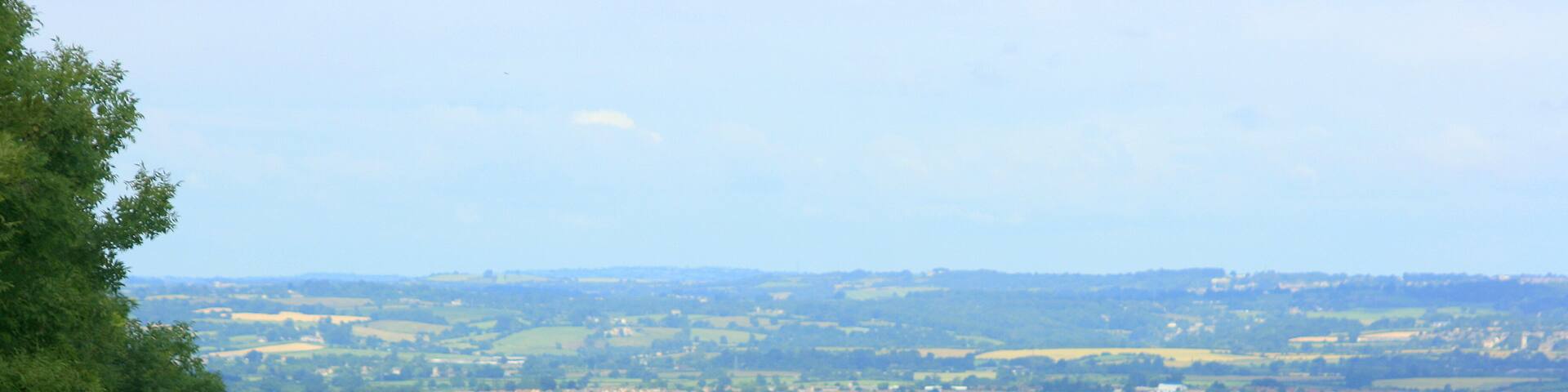 View west from Coulston Hill, near Edington At the edge of a wheatfield. The built up area is Trowbridge, the hills further over are around Bradford on Avon and Westwood, beyond that are Somerset hills south of Bath.