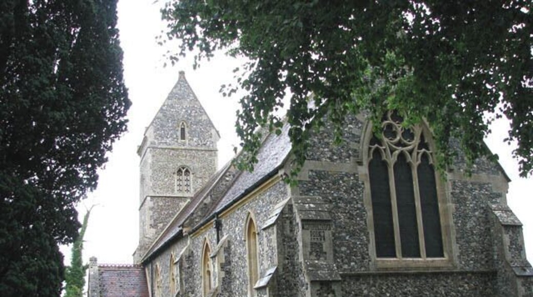 The church of St Ethelbert in East Wretham. The church of St Ethelbert > 1404082 with its distinctive saddleback tower was rebuilt in 1865 for the Birch family by the architect George Street and furnishings as well as stained glass > 1758761 date from this time. The only older survival is the Norman south doorway > 1404084. The font was made in 1883 of Corsham stone and the font cover > 1758750 was designed by architect JA Reeve, who based his design upon the medieval one in St Mary's church in Elsing > 890945. The frescoes on the east wall > 1758744 were painted 150 years ago by the then Rector, Revd JP Whalley, who also painted the font cover > 1758751 and the carved reredos > 1758748. What is believed to be an unusual royal arms - it is for Queen Elizabeth I (1558-1603) - in stained glass > 1758756 can be found set into a north wall window, hiding behind the organ > 1758754 which is a particularly good example of an early instrument built by James Corps in 1866, and is listed as Grade II in the British Institute of Organ Studies' register for historic pipe organs. The floral decoration on the organ case - executed by Revd JP Whalley - was discovered under a thick coat of blue paint which has since been painstakingly removed.