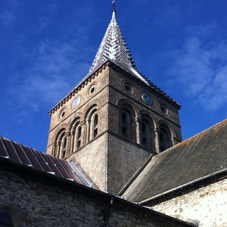 A church tower with a pointed spire and arched windows.