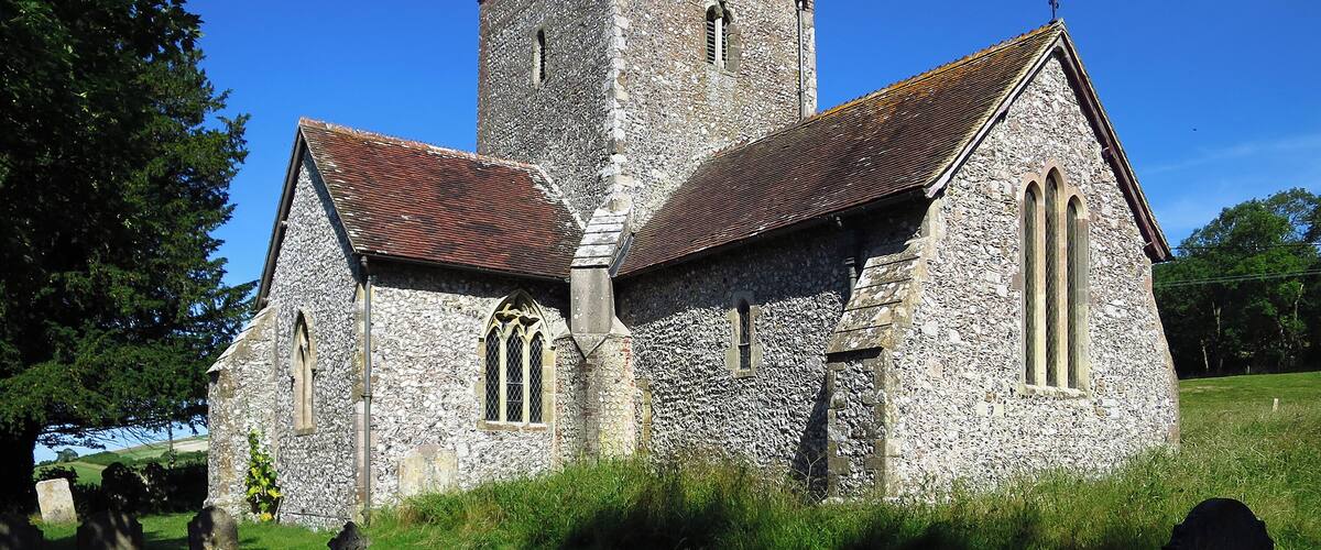 A stone church with a tower and arched windows.