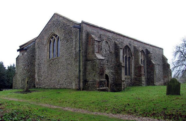 An old stone church with arched windows and a graveyard in the foreground.
