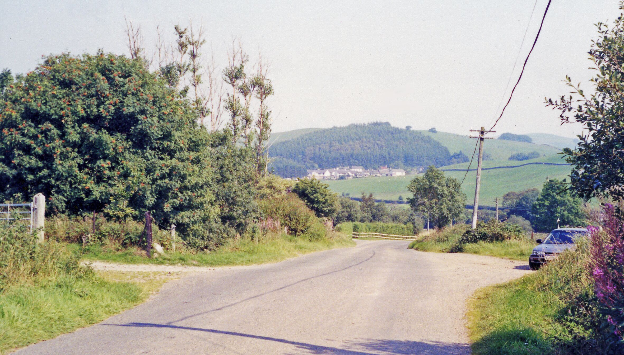 Eastward across Cairn Water valley at site of Dunscore station. View NE: the station had been on the left: ex-G&SW Dumfries - Moniaive Light Railway; all closed to passengers 3/5/43, to goods 4/7/49 - just a gateway is left in 1991.