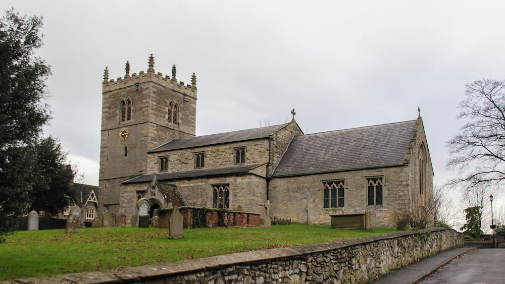 A historic stone church with a tall tower and a large arched entrance.