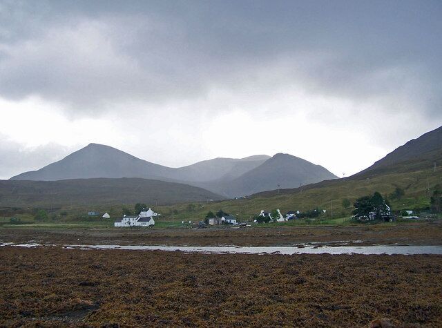 Cottages in Strollamus from the beach The highest of the hills in the background is Beinn na Caillich.