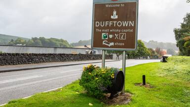 A welcome sign for Dufftown, indicating it's the malt whisky capital, with a speed limit sign of 40.