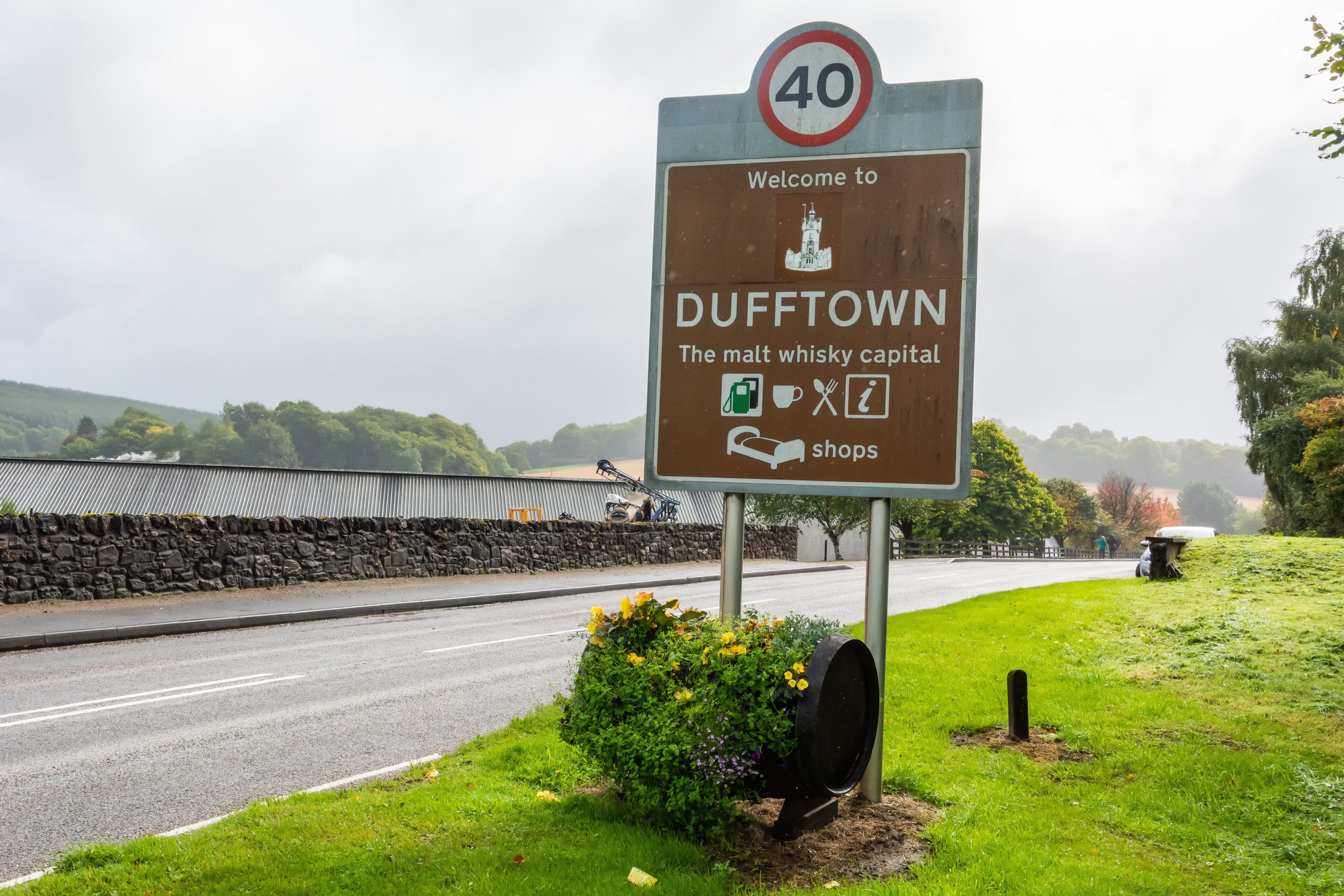 A welcome sign for Dufftown, indicating it's the malt whisky capital, with a speed limit sign of 40.