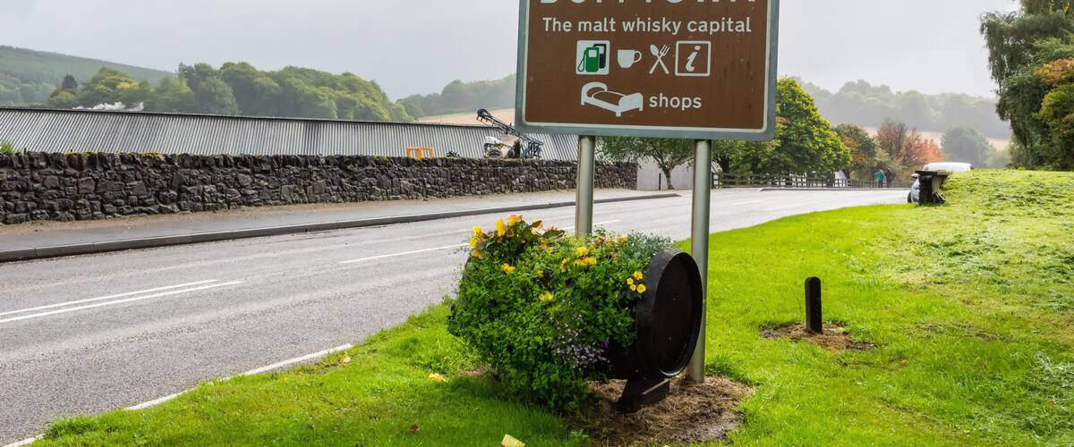 A welcome sign for Dufftown, indicating it's the malt whisky capital, with a speed limit sign of 40.