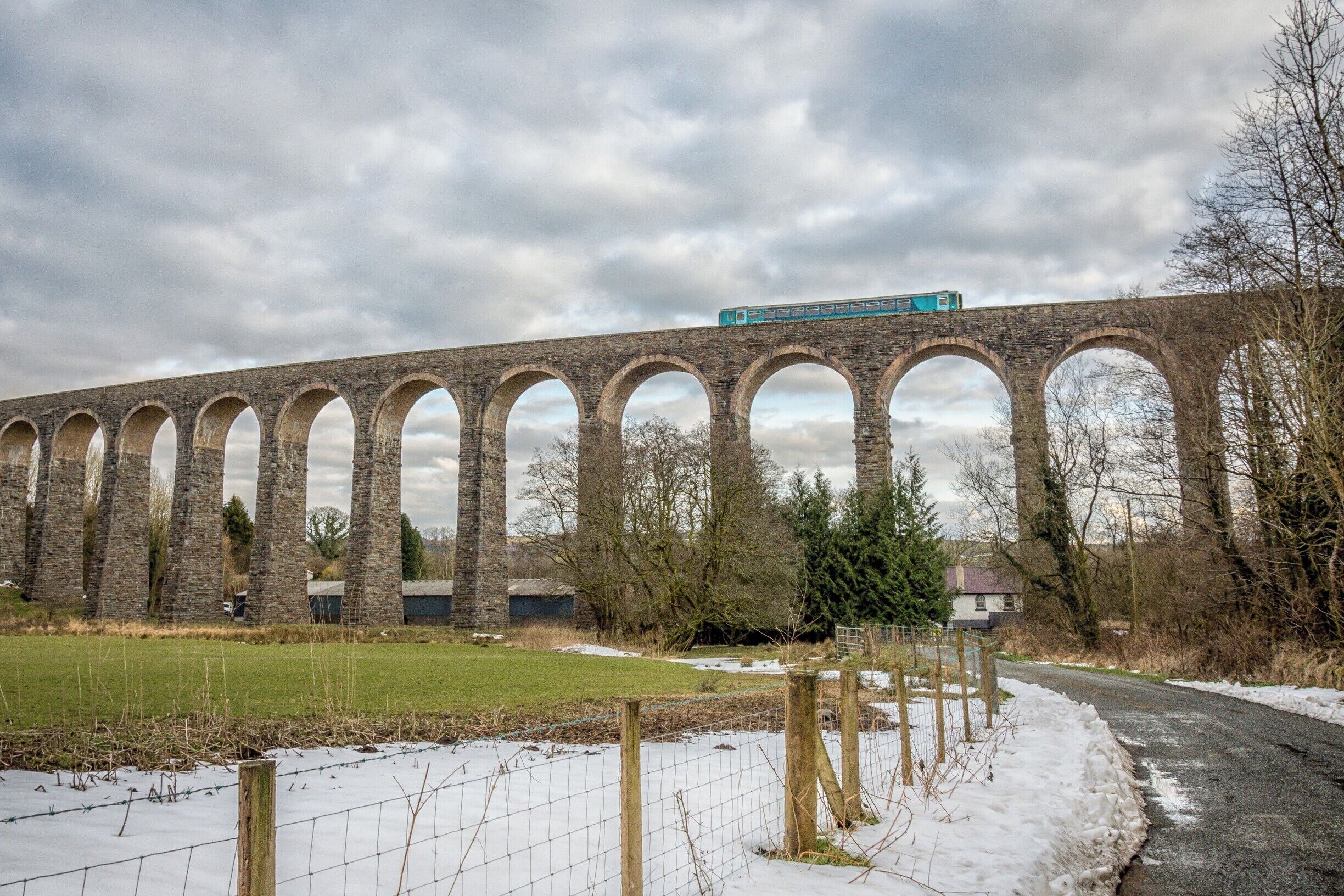 A stone viaduct with a train crossing over it.