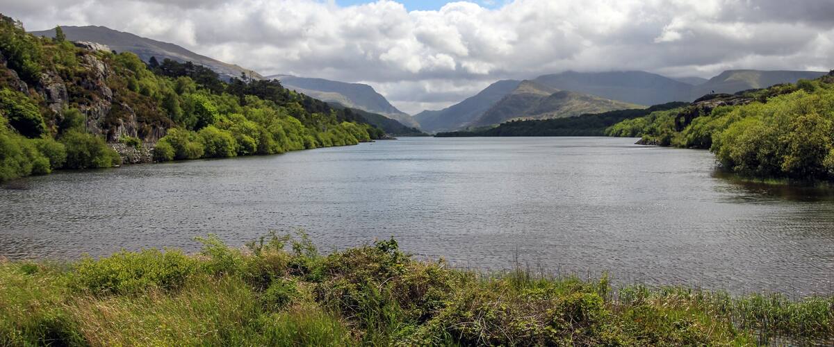 A lake surrounded by mountains and lush greenery.