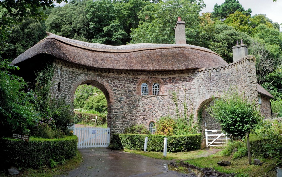 Una casa de piedra con techo curvo y ventanas arqueadas.