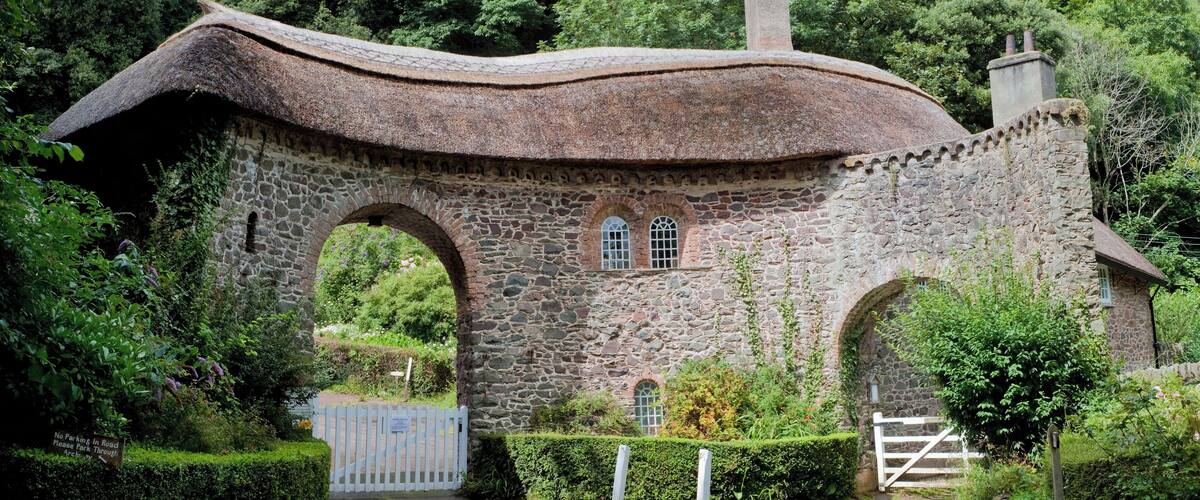 A stone house with a curved roof and arched windows.