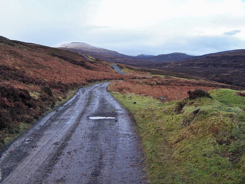 Track from Fasach A well made track leads from the end of the road in Lower Fasach to an isolated building on the moor. In the background is a misty and snow capped Healabhal Mhòr in grid square NG1851.