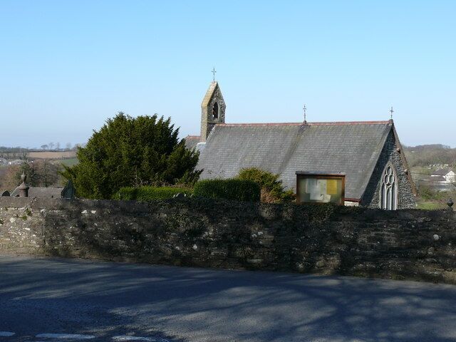 A stone church with a bell tower and a small window.