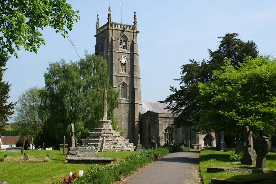 A church with a tall tower, a graveyard, and a pathway.