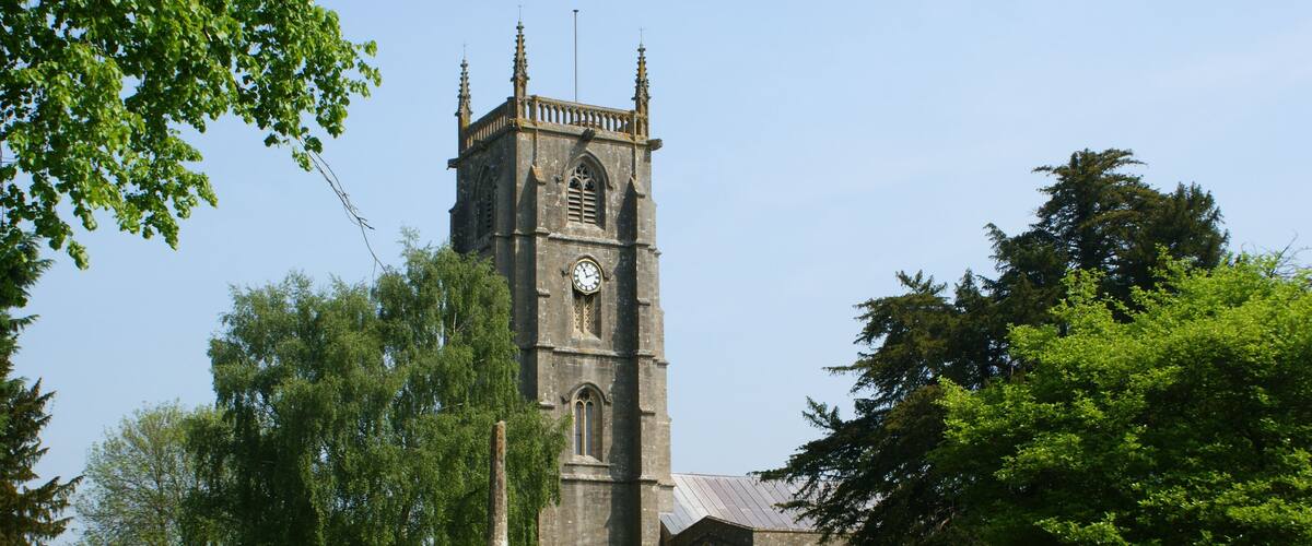 A church with a tall tower, a graveyard, and a pathway.