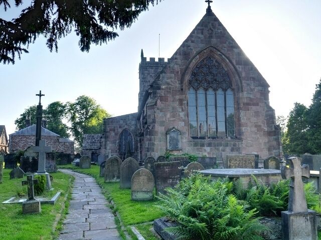 A church with a pointed steeple and a large arched window.