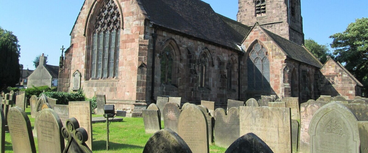 A church with a tall tower and a large arched window.