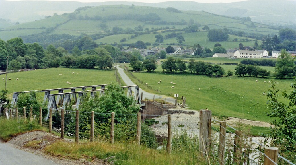 Eastward across Avon Dyfi valley at Cemmaes. Down in the bottom used to be the Mawddy branch of the Cambrian Railway (GWR) from Cemmaes Road to Dinas Mawddy, which closed to passengers from 1/1/31 but was open for goods until 1/7/51. In the background are the Mynydd Cemmaes, rising to 1,296 ft.