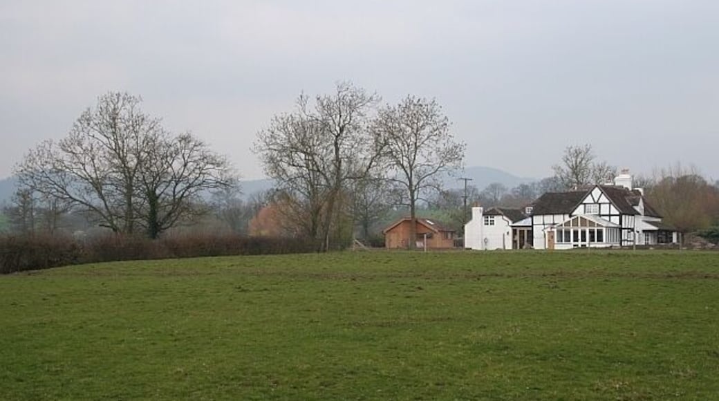 Sansome's Farm, Drugger's End A well extended timber-framed farmhouse. The Malvern hills can be seen in the distance beyond the trees.