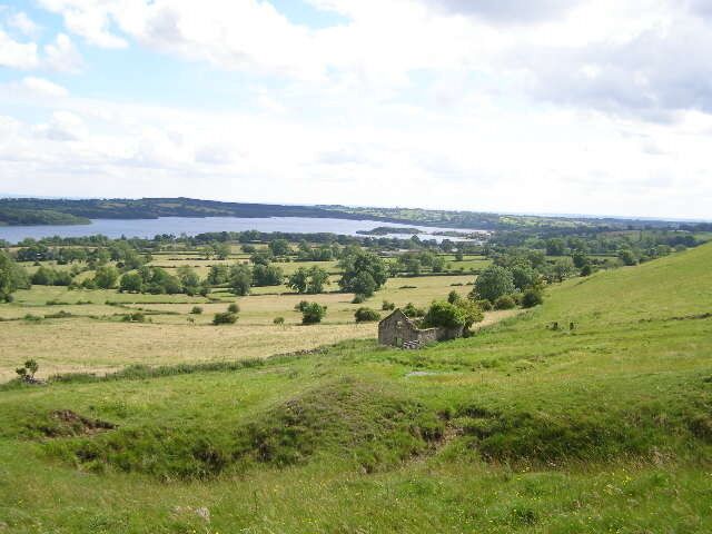 Derelict Farm Building An isolated derelict barn - without a roof - in the foreground and part of Carsington Water in the background.