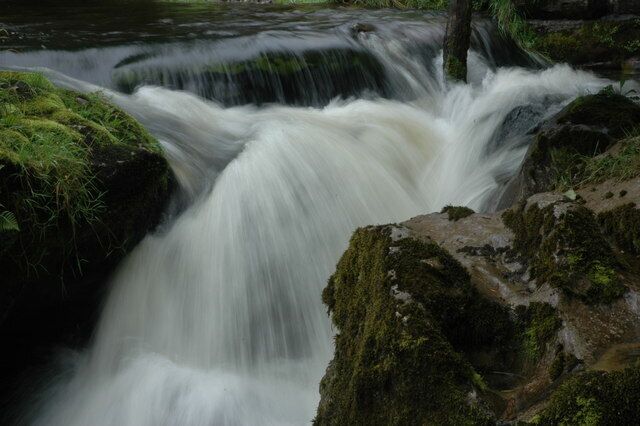 A waterfall cascading over moss-covered rocks.