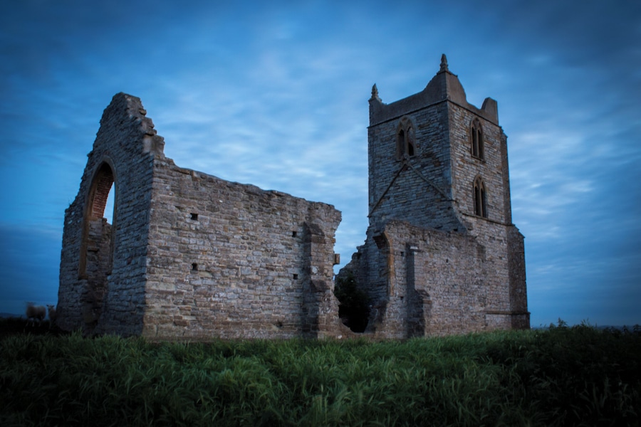 An ancient stone structure with arched ruins and a bell tower.