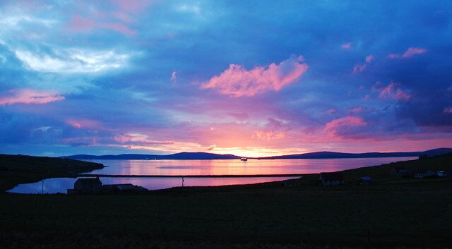 A sunset over a lake with a distant mountain range.