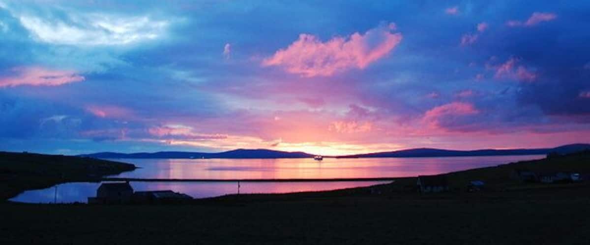 A sunset over a lake with a distant mountain range.