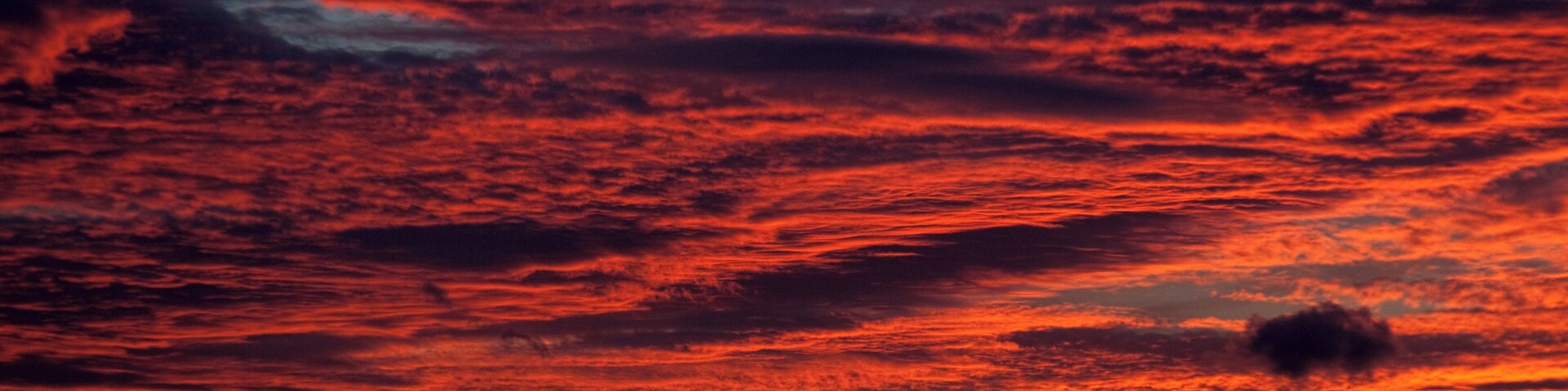 Ein Sonnenuntergang mit einem leuchtend roten und orangefarbenen Himmel.