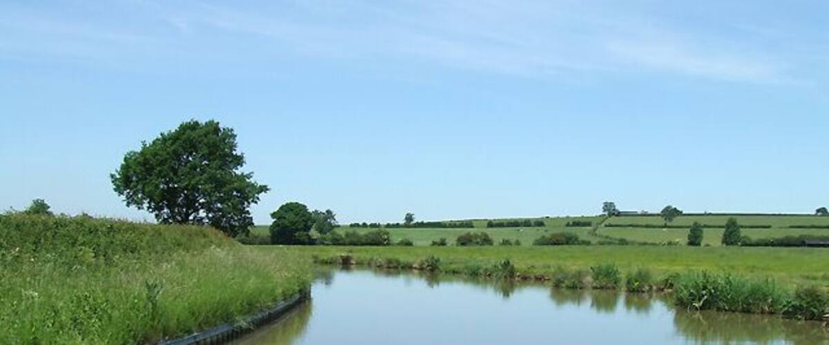 Oxford Canal north of Braunston, Northamptonshire Approaching the Northamptonshire - Warwickshire boundary. The Oxford Canal was one of the earliest, and for a long time one of the most important canals in the south midlands.James Brindley started the construction soon after authorisation in 1769, but after he died in 1772 Samuel Simcock eventually completed the winding 91 mile course from Hawkesbury Junction (with the Coventry Canal) and Oxford in 1790. Huge re-routing in the late 1820s cut 14 miles off the original 36 mile course between Braunston and Hawkesbury.
