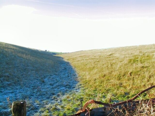 Shuttle Rake. Even at noon, the frozen ground on the north-facing slope of the depression remains untouched by the sun. Looking west up Shuttle Rake towards the old open cast workings.