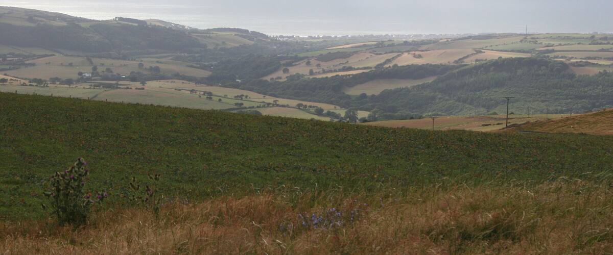 Rolling hills, a distant coastline, and a clear sky.