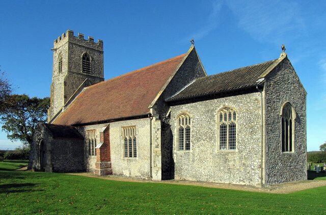 A stone church with a bell tower and arched windows.