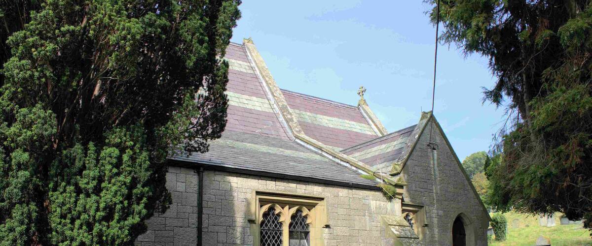A stone church with a pointed roof and a small arched entrance.