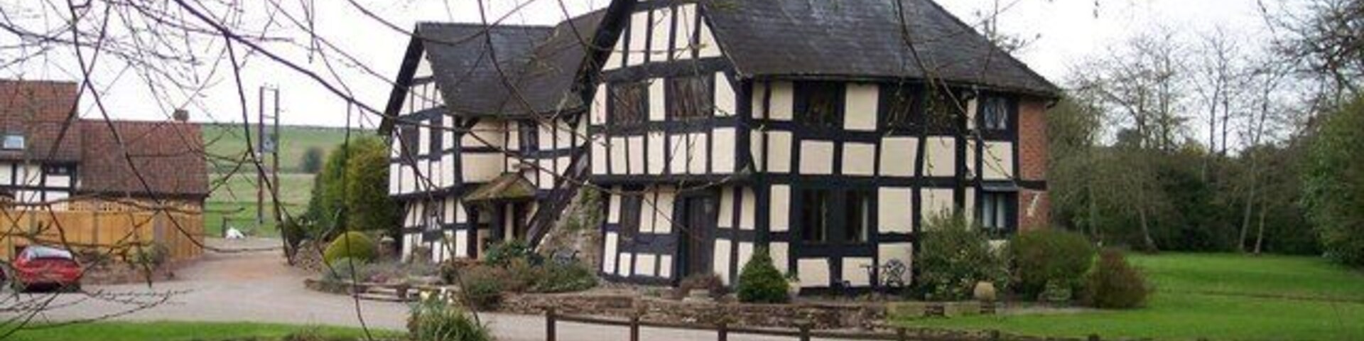 Una casa tradicional con entramado de madera junto a un cuerpo de agua tranquilo.