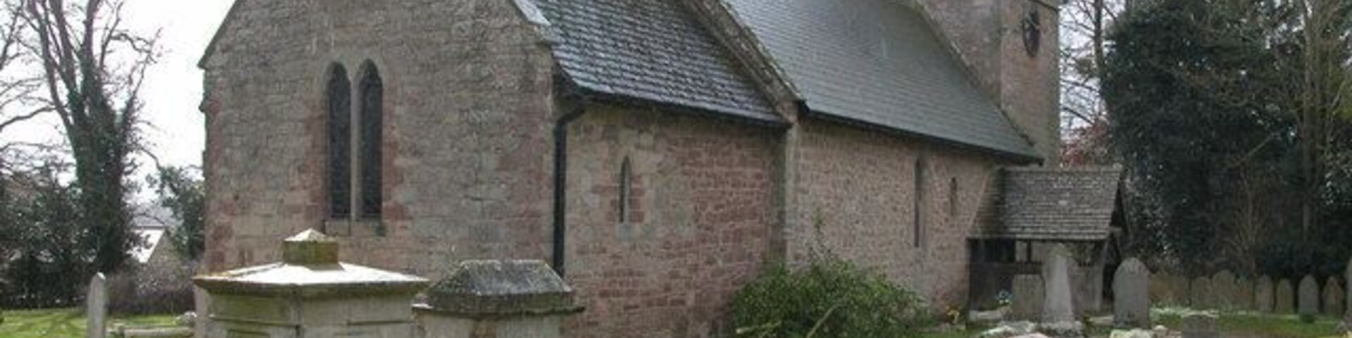 Sutton St Nicholas Church. On the day of my visit tree surgeons were cutting back some of the branches on the trees, hence the branches lying in front of the church.