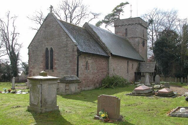 A small stone church with a bell tower and a graveyard.
