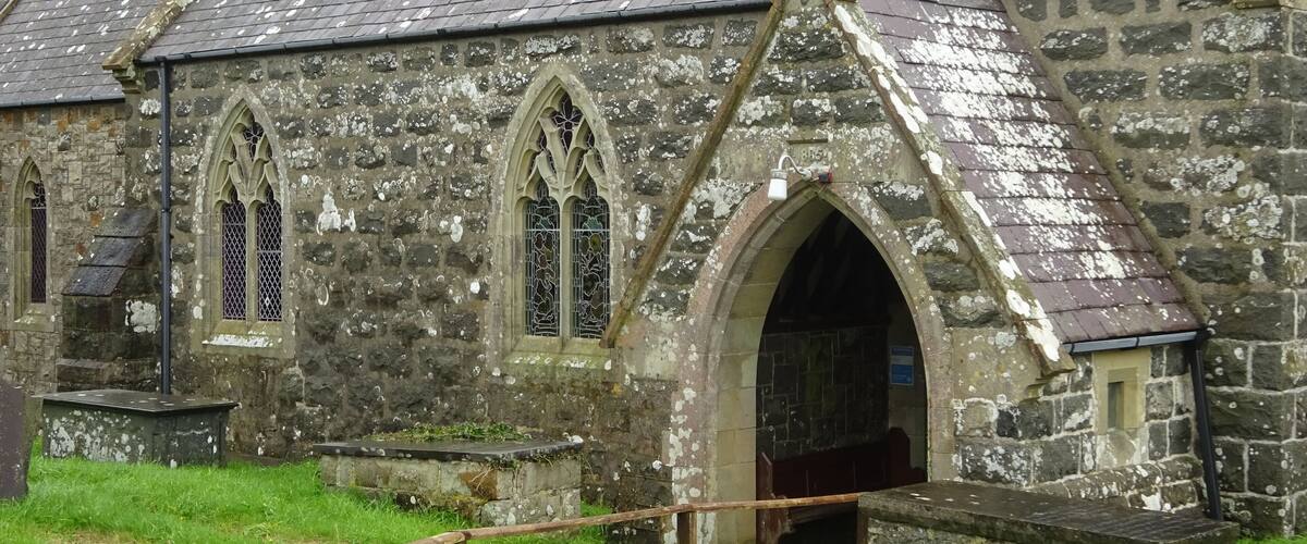 A historic stone church with pointed arches and a tiled roof.