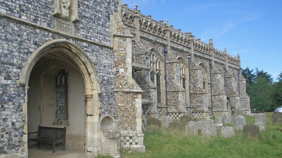 A historic stone building with intricate carvings and a large arched doorway.
