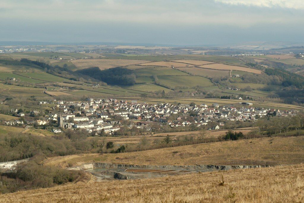 A rural town with rolling hills and fields in the background.