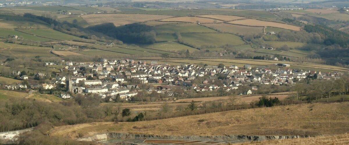 A rural town with rolling hills and fields in the background.