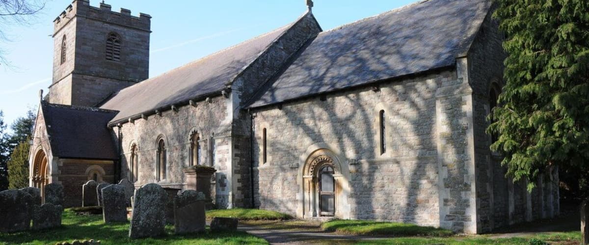A stone church with a tower and a graveyard.