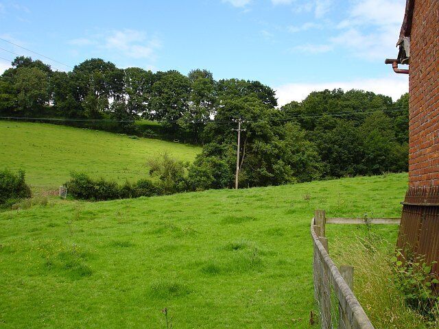 View from the Schoolroom. On the northern edge of the churchyard at 504827 stands a small brick building which was the original schoolroom for the village and has a datestone 1852. This is the view past it.