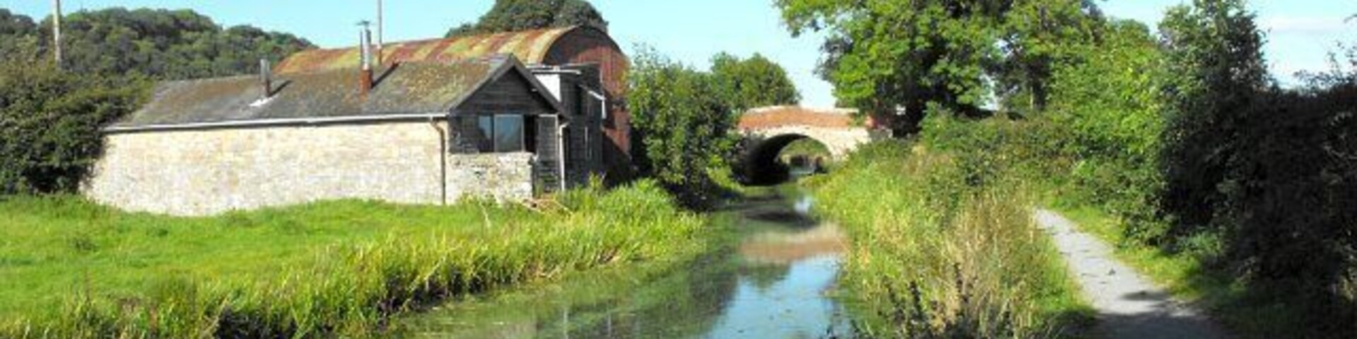 The Wharf, Berriew. The three sheds on the left, once known as Lloyd's Coal Wharf, are the workshops of William O'Brien, artist blacksmith 1482064. They stand beside the Montgomery Canal and straddle the northern edge of the square. Long Bridge (No 128) beyond carries the B4390 and stands in SJ1901. All my photos of this building https://www.geograph.org.uk/search.php?i=8029697