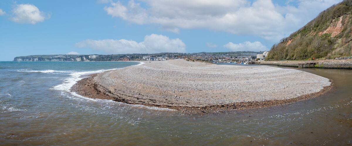 Panoramic view of U shaped entrance to Axmouth harbour with large spit of shingle