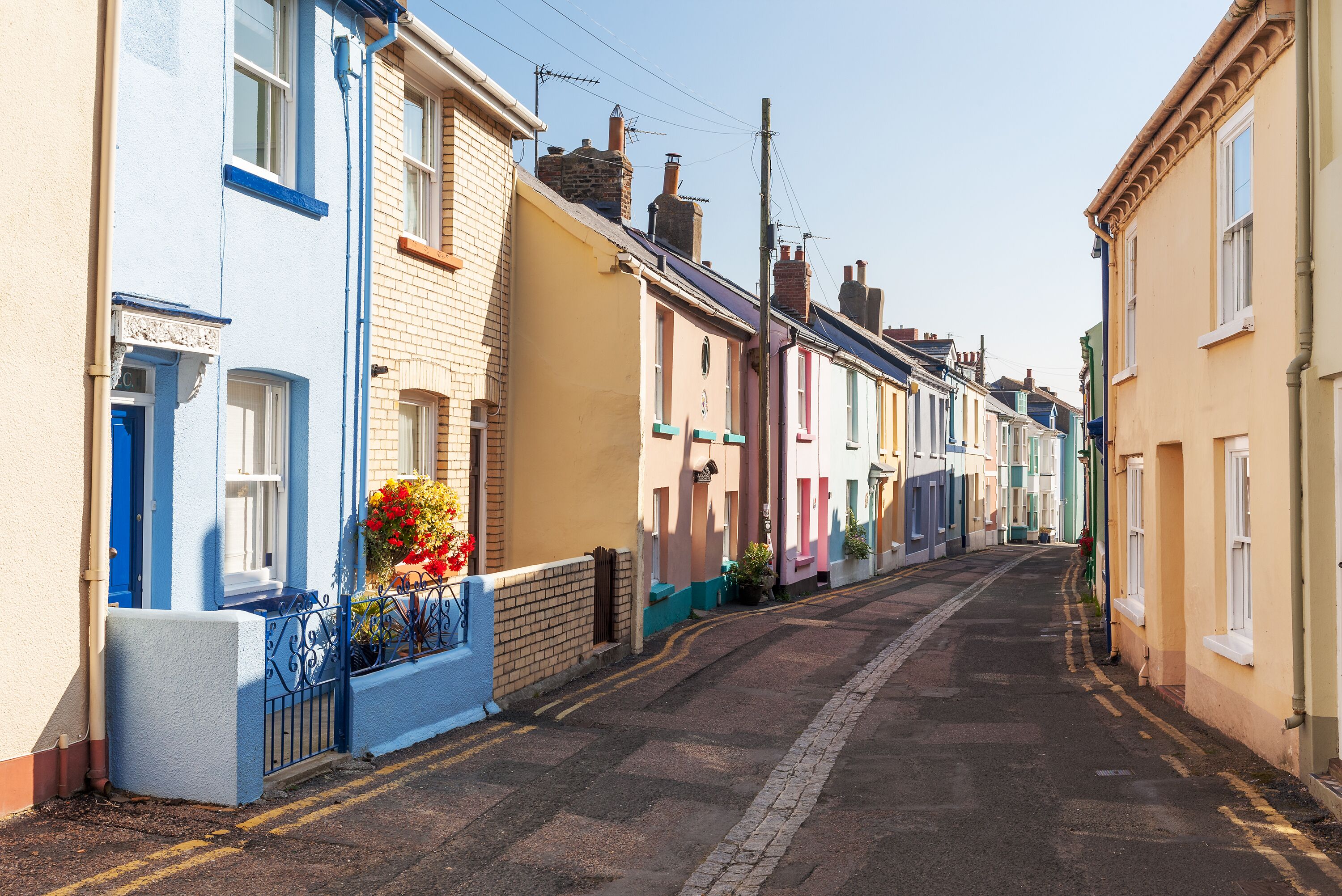 A narrow street lined with colorful terraced houses.