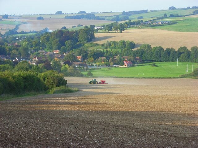 Farmland above Aldbourne Looking towards the village from Southward Down. The tractor seemed to be applying fertiliser.