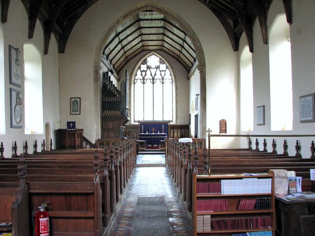 All Saints church in Alburgh - view east. The tower of All Saints church > 1770481 is very tall and can be seen for miles. It is believed that the church stands on an older place of worship. The bottom section, built in the 15th century from flints found in the surrounding fields, is contemporary with the rest of the building. The church was extensively restored and partially rebuilt in the 19th century but the C15 rood screen dado > 1770503 has survived. Everything else dates from the Victorian restoration as do the stained glass windows > 1770510.